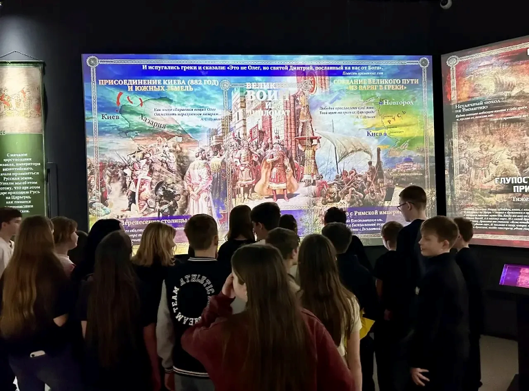 Ученик смотрят на стенд.